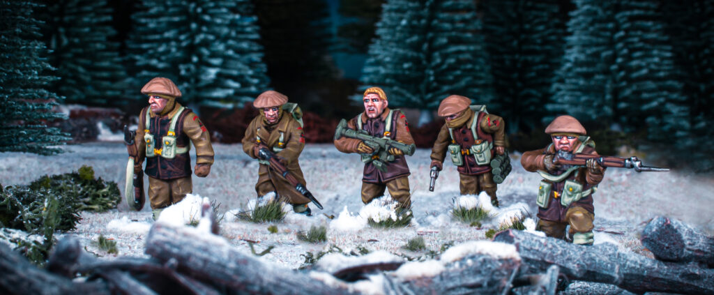 Winter British Infantry by Warlord Games advance through a snowy forest.